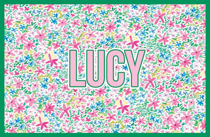 Paper placemat featuring a multicolored floral pattern and pink personalization