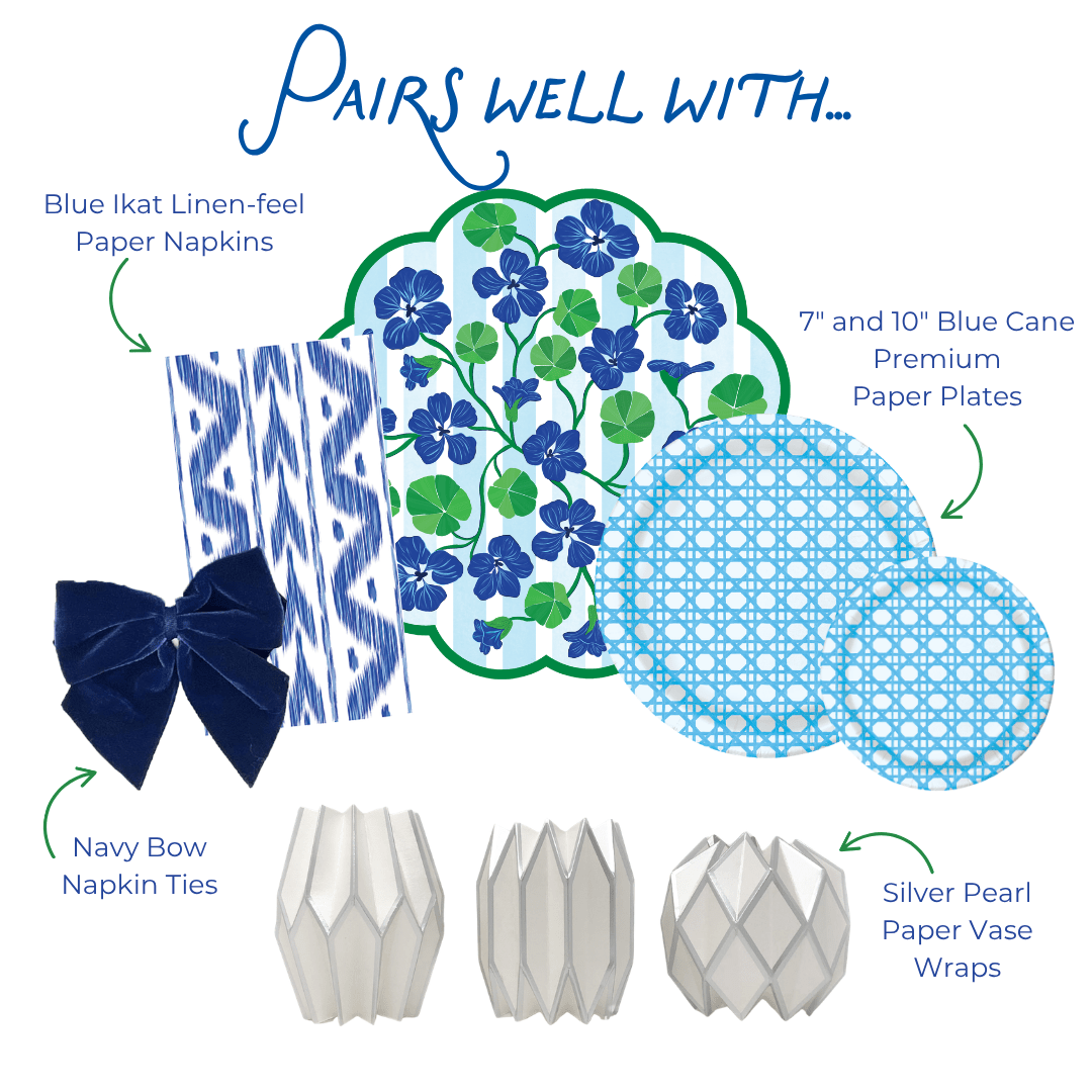 Graphic showing coordinating table decor items including blue ikat-style paper napkins, a blue and green floral scalloped placemat, blue patterned paper plates in two sizes, navy bow napkin ties, and silver geometric paper vase wraps, labeled as items that pair well together.
