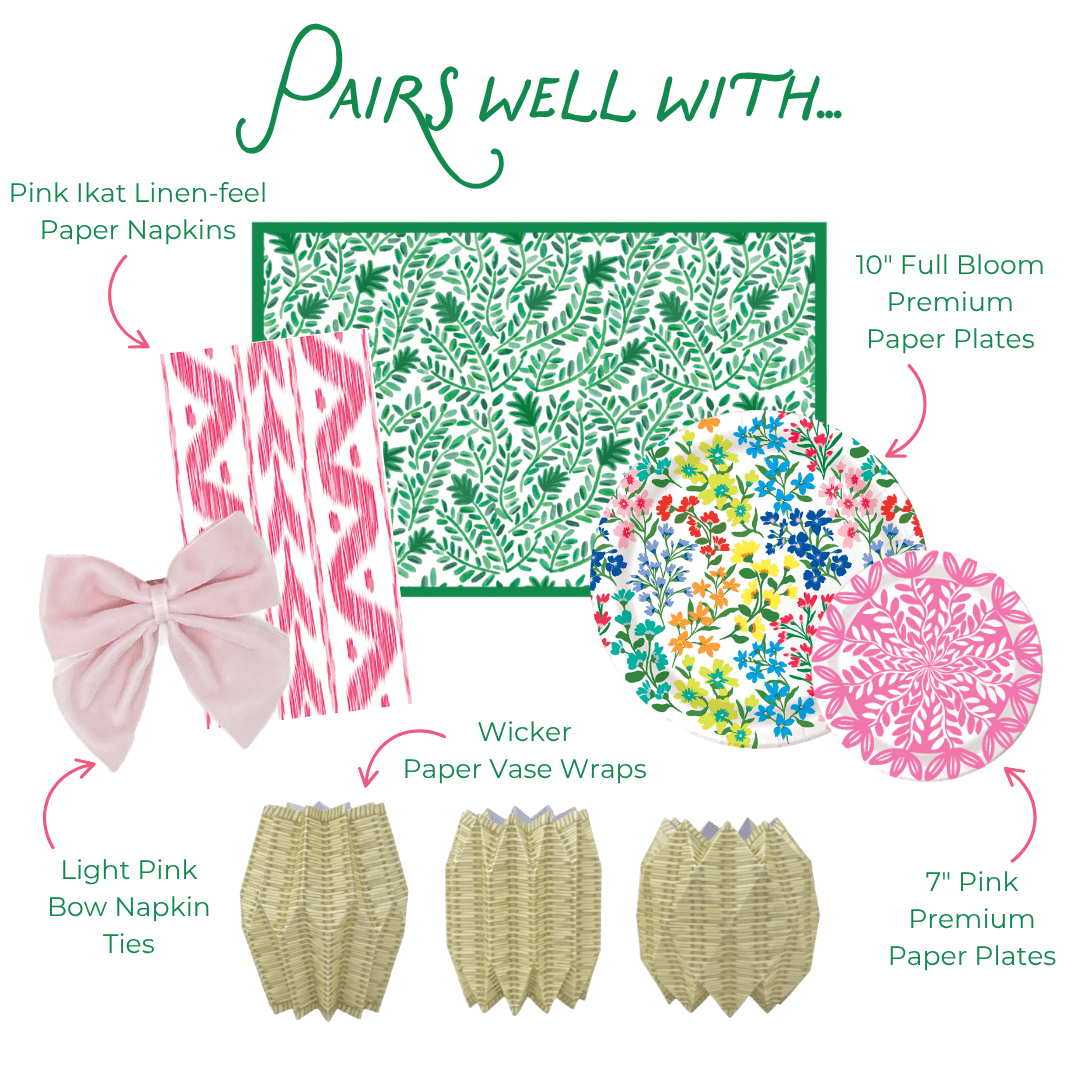 Product assortment with pink ikat linen-feel paper napkins, green floral-patterned paper, colorful floral paper plates, light pink bow napkin ties, wicker paper vase wraps, and pink heavy-duty paper plates.