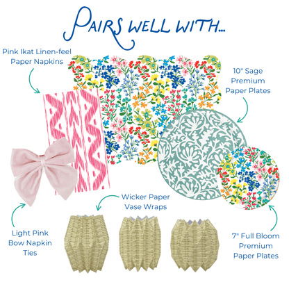 Graphic showing coordinating table decor items including pink ikat-style paper napkins, multicolor floral scalloped placemat, sage green and floral-patterned paper plates, light pink bow napkin ties, and wicker-style paper vase wraps, labeled as items that pair well together.