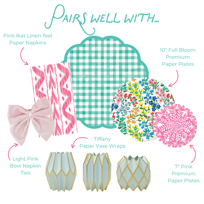 Pairs well with graphic showing six coordinating party products: Pink Ikat Linen-feel Paper Napkins in a pink and white ikat stripe pattern; Light Pink Bow Napkin Ties in soft velvet; Tiffany Paper Vase Wraps in pale blue with gold geometric lattice; a teal green gingham scallop-edged plate; 10-inch Full Bloom Heavy-duty Paper Plates with a colorful wildflower print in pink, blue, yellow, and red; and 7-inch Pink Heavy-duty Paper Plates with a bold pink floral medallion print.