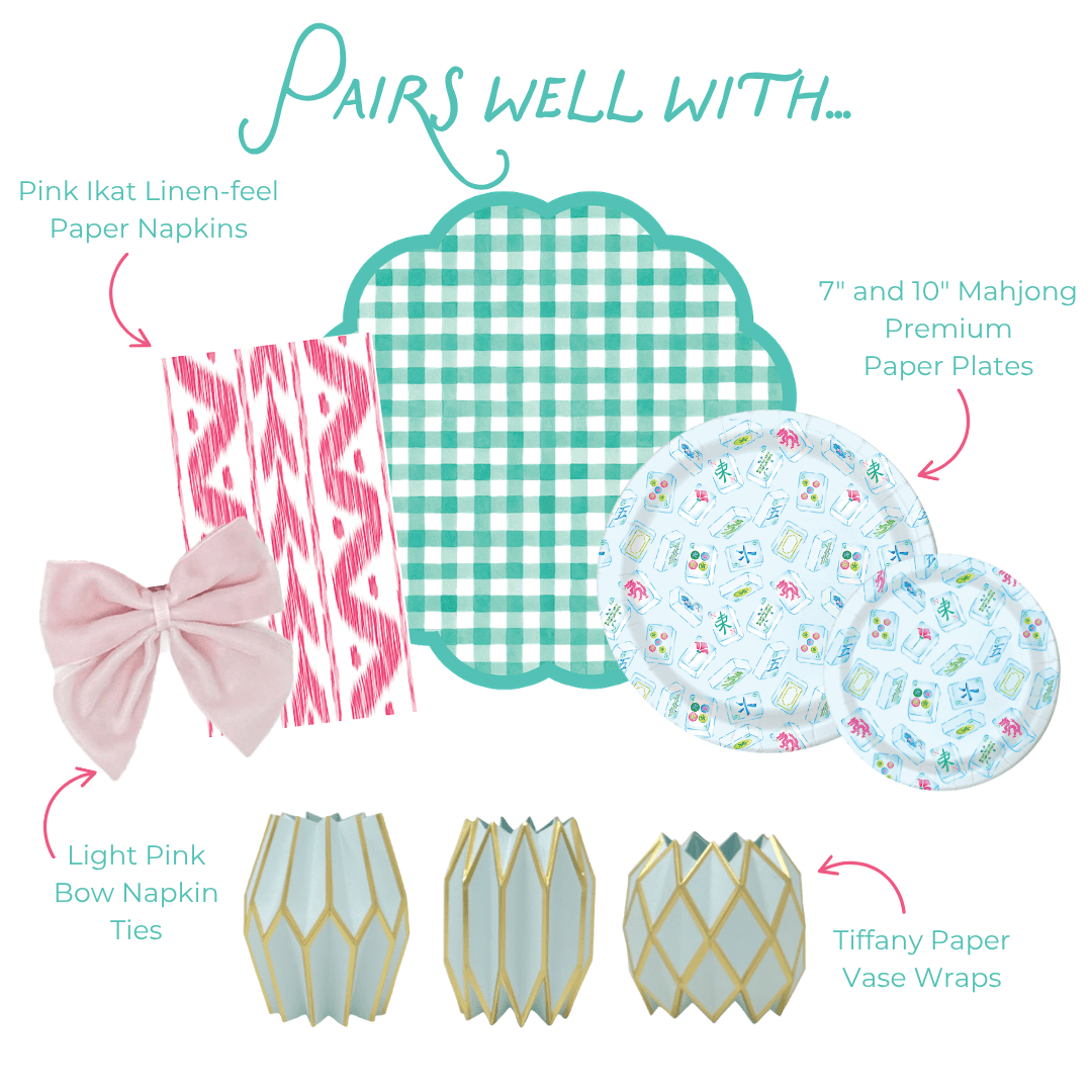 Product assortment including pink ikat paper napkins, teal checkered placemats, floral paper plates, light pink bow napkin ties, and decorative paper vase wraps on a white background