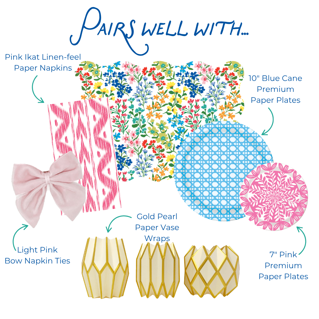 Graphic showing coordinating table decor items including pink ikat-style paper napkins, multicolor floral scalloped placemat, blue patterned and pink floral paper plates, light pink bow napkin ties, and gold geometric paper vase wraps, labeled as items that pair well together