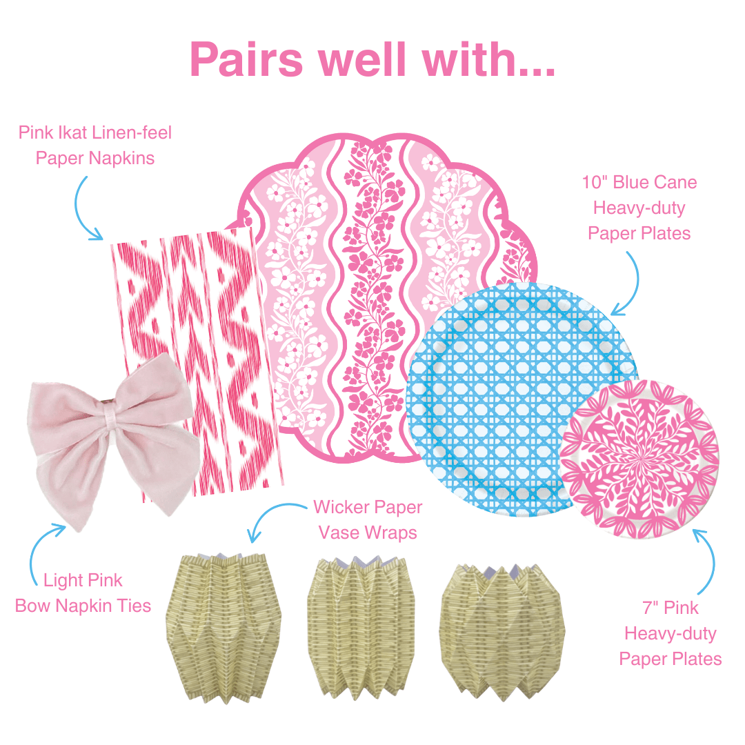 Graphic showing coordinating table decor items including pink ikat-style paper napkins, pink floral scalloped placemat, blue patterned and pink floral paper plates, light pink bow napkin ties, and wicker-style paper vase wraps, labeled as items that pair well together.