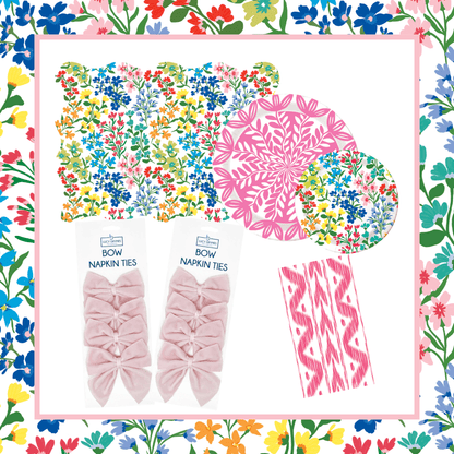 Full Bloom and Pink Bundle featuring a scallop-edged wildflower print placemat, two packs of Light Pink Bow Napkin Ties, a pink ikat print napkin, a 10-inch pink floral medallion plate, and a Full Bloom wildflower print plate, displayed on a colorful wildflower print border
