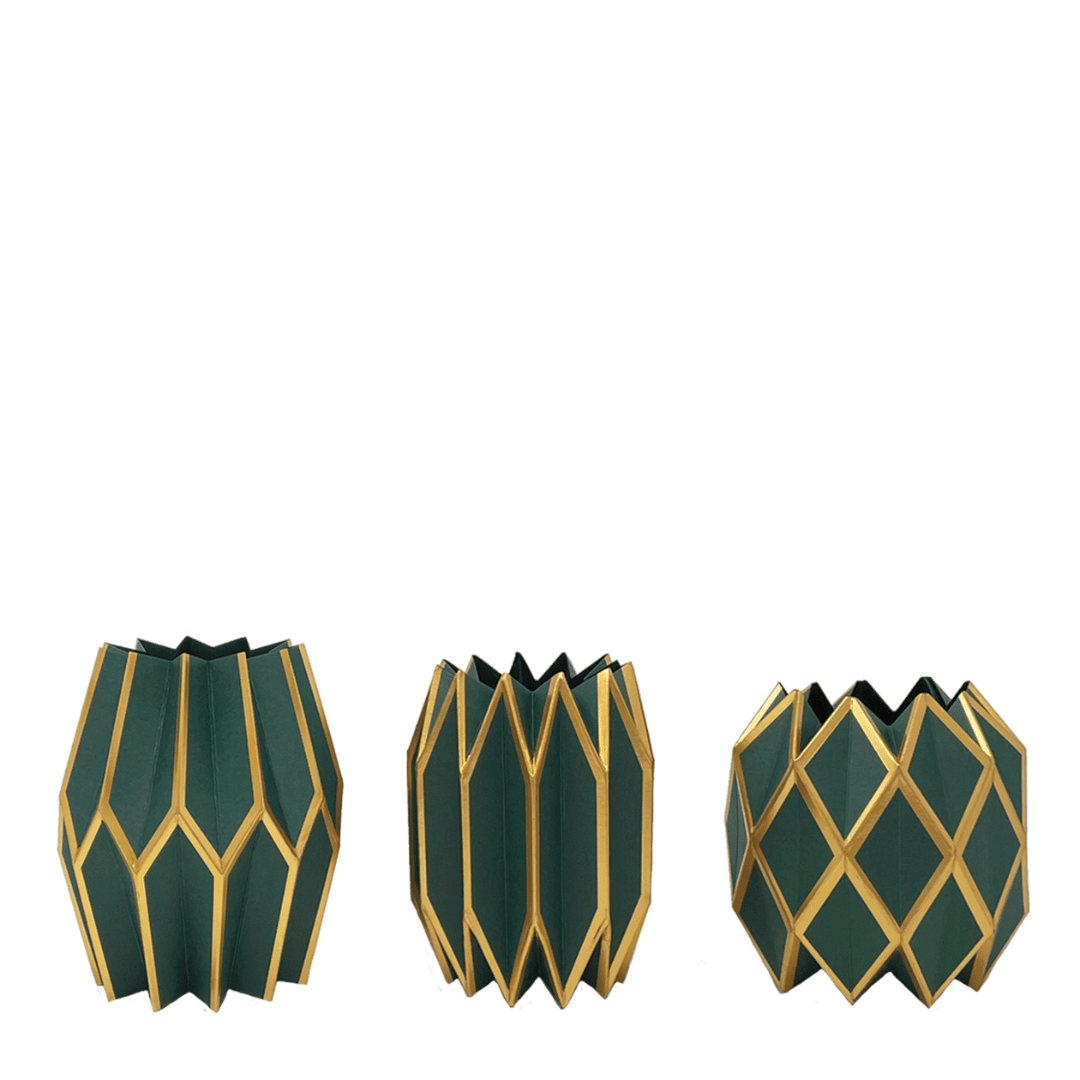 Three green and gold geometric candle holders on a white background