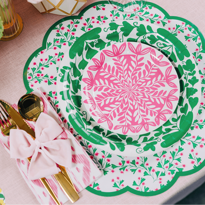 Decorative floral plates with pink and green patterns on a floral paper table setting.