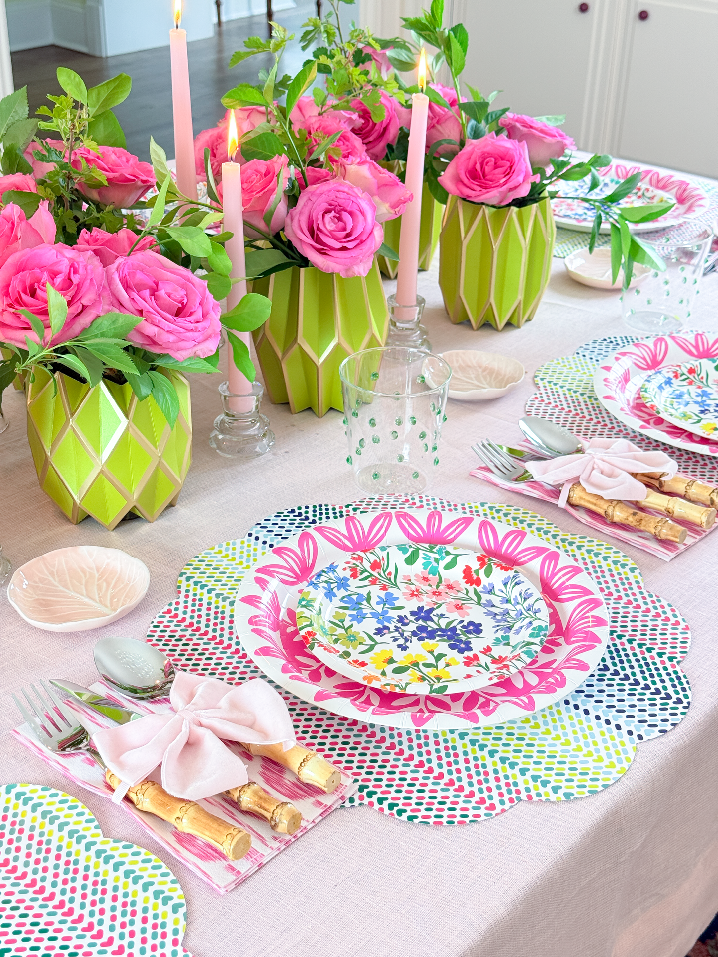 Decorative table setting with floral centerpieces, colorful plates, and patterned placemats.