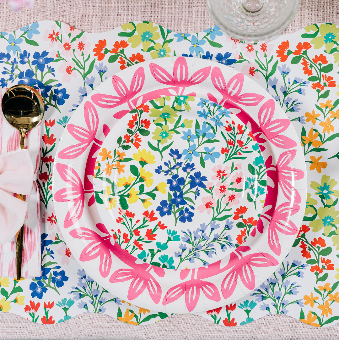 Colorful floral-patterned plates on a matching placemat with cutlery.