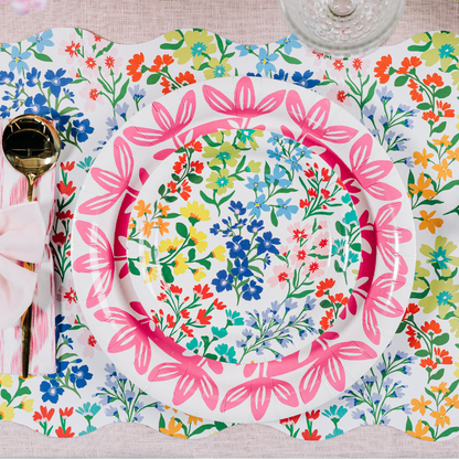 Colorful floral-patterned plates on a matching placemat with cutlery.