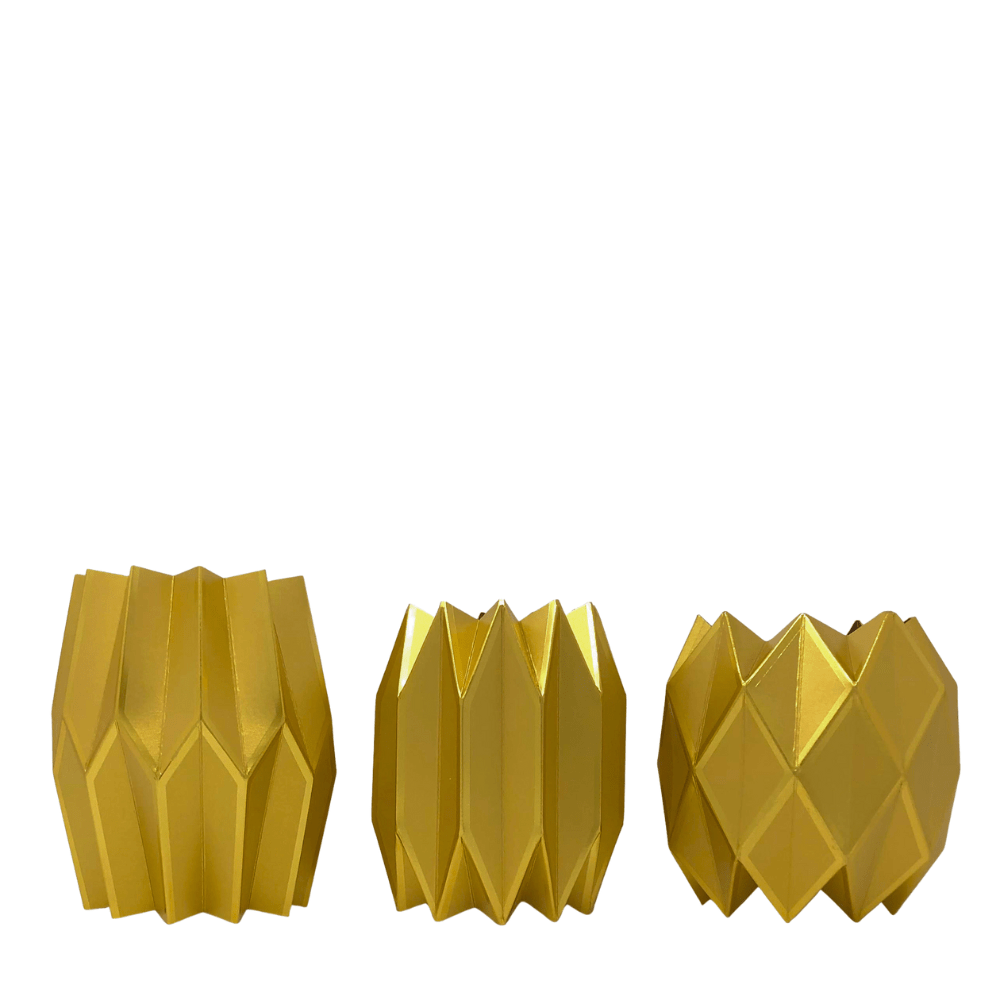 Three gold geometric-patterned paper vases on a white background