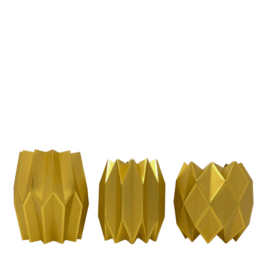 Three gold geometric-patterned paper vases on a white background