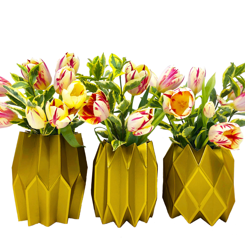 Three gold geometric paper vases with tulips on a white background