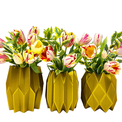 Three gold geometric paper vases with tulips on a white background