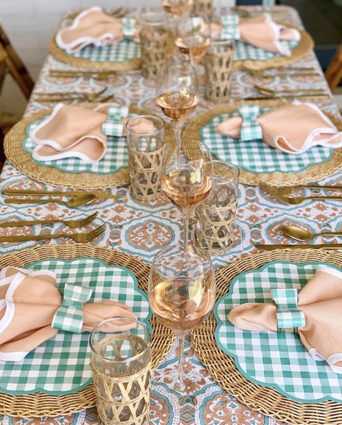 Fall table with green gingham paper placemats and coral napkins with bowtie napkin rings