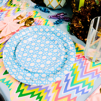 Colorful table setting with zigzag paper placemats, blue cane and patterned paper plates