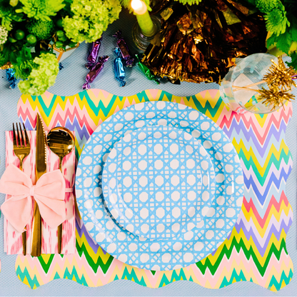 Colorful zigzag placemat with a blue  and white, gold cutlery, and decorative elements on a table.