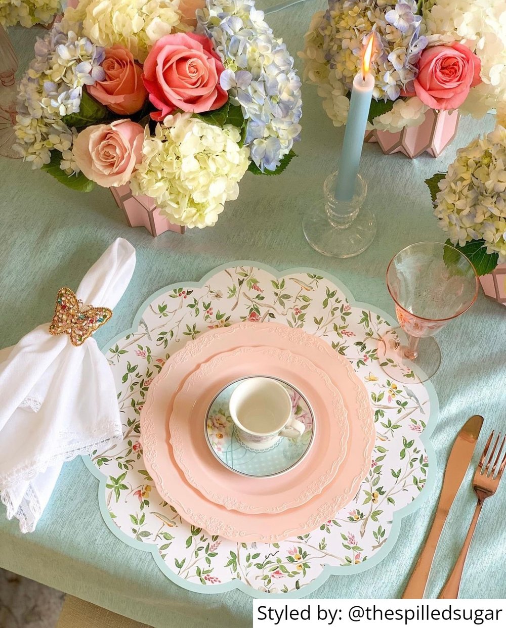 Pink Galentines Day tea party table setting with paper placemats and teacups