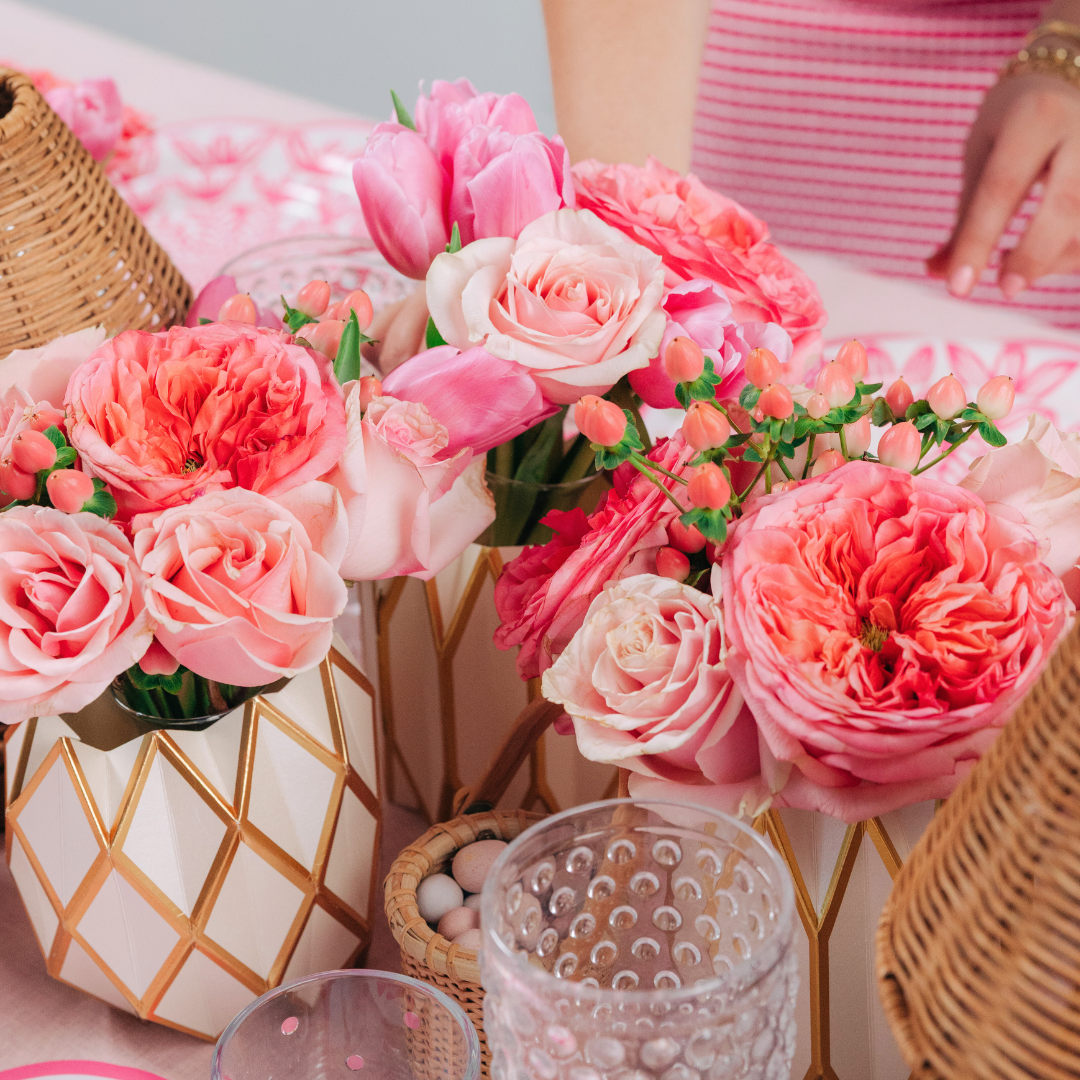 White and gold geometric pattern paper vase wraps styled with pink roses and tulips on a spring table setting