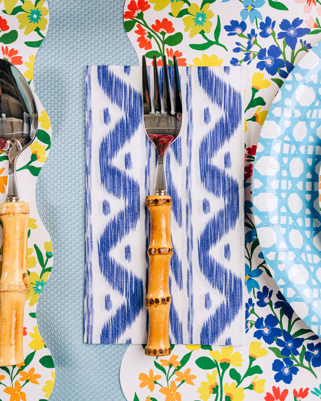 Fork with bamboo handle on a patterned napkin surrounded by colorful floral paper products