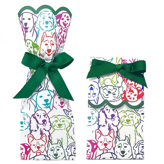 Two paper gift bag kits in a multicolor dog portrait print, shown tied as a tall wine bag and a shorter gift bag, each with a green ribbon bow