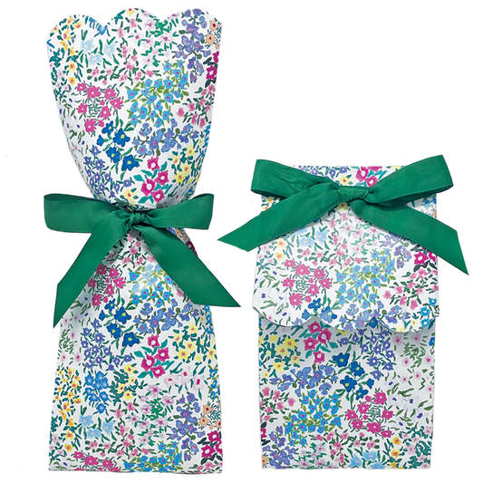 Two paper gift bag kits in a multicolor ditsy floral print, shown tied as a tall wine bag and a shorter gift bag, each with a green ribbon bow