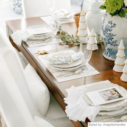 Table setting with white floral paper placemats on a wood table