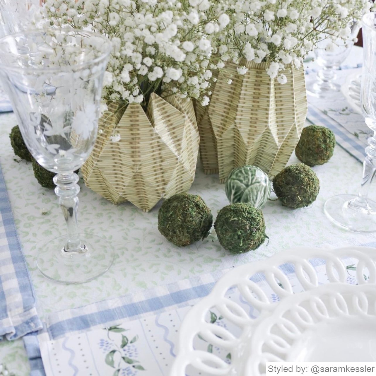 Wicker paper vases with baby's breath on a blue tablecloth