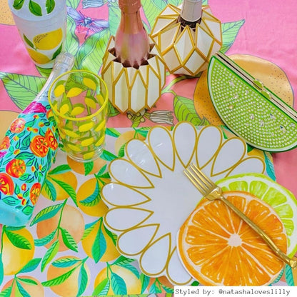 Bright table setting with orange paper placemats layered with other orange, green and gold table decor