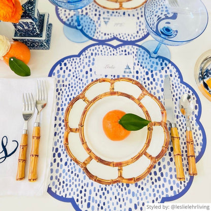 Blue and white dot patterned paper placemat layered with bamboo elements and an orange