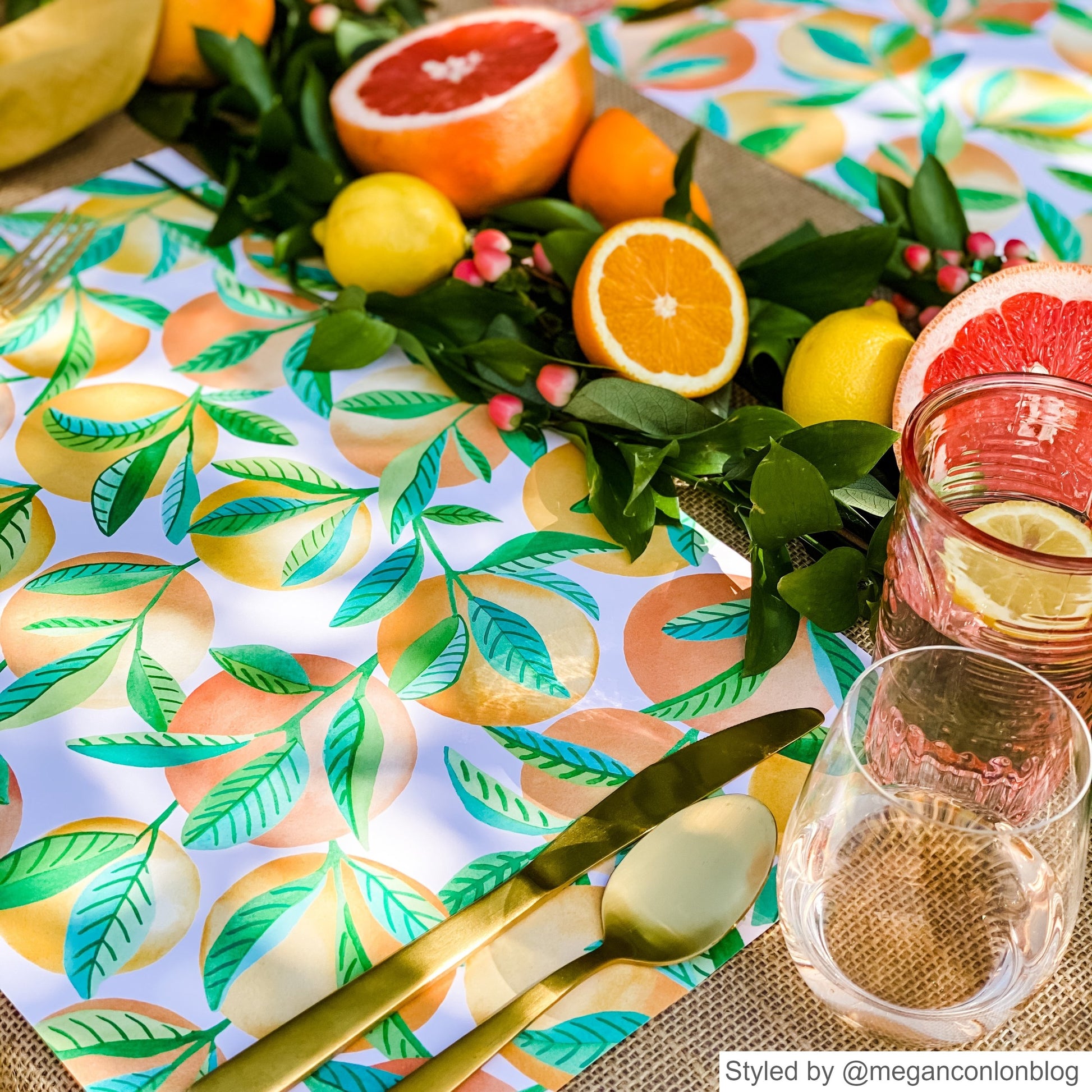 Place setting with orange patterned paper placemats and cut open oranges as a centerpieces