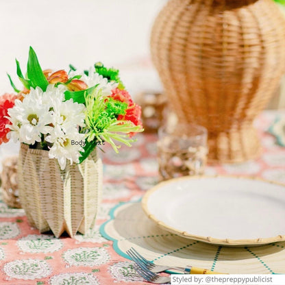 Wicker paper vase on a table with white flowers