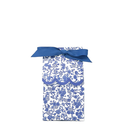 Blue and white chinoiserie paper wine bag tied as a gift bag with a blue ribbon