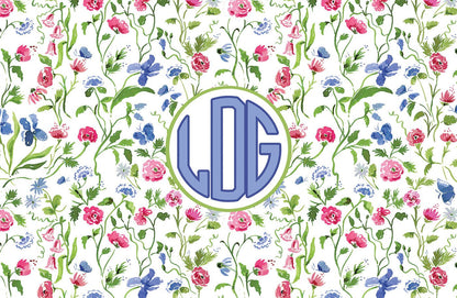 Paper placemat featuring a floral pattern on a cream background with a periwinkle circle monogram