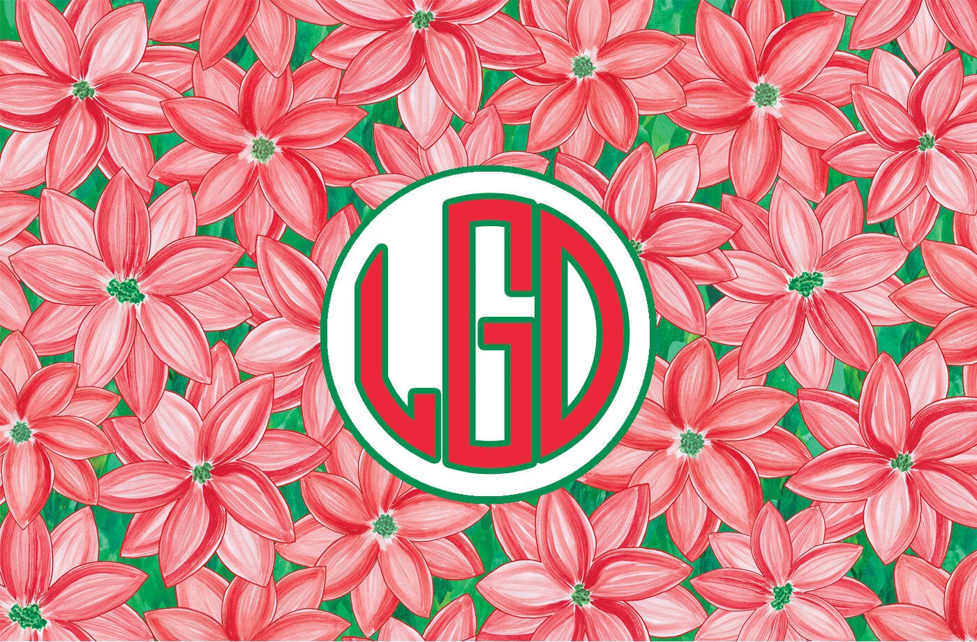 Paper placemat with a red and green poinsettia pattern and a red and green circle monogram