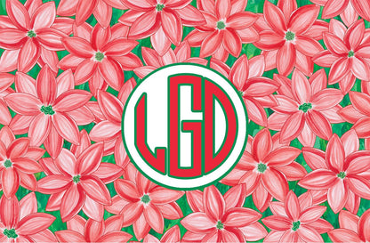 Paper placemat with a red and green poinsettia pattern and a red and green circle monogram