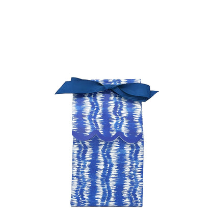 Paper wine bag with blue and white ikat pattern tied as a gift bag with a blue bow