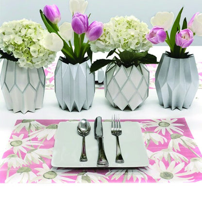 Table setting with pink floral paper placemat and silver centerpieces