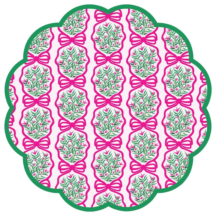 Round scalloped paper placemats featuring a pink and green wreath pattern on a light pink background with green border