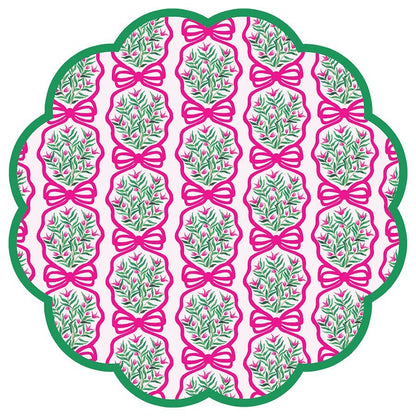 Round scalloped paper placemats featuring a pink and green wreath pattern on a light pink background with green border