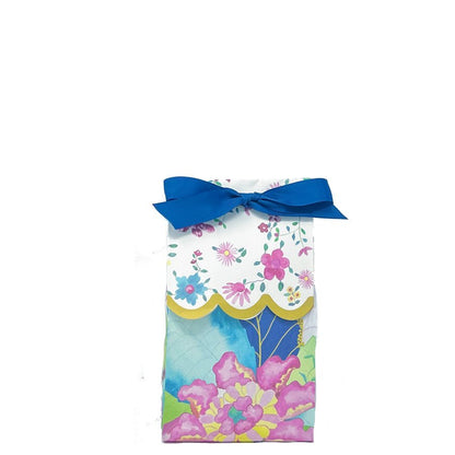 Paper wine bag featuring a tobacco leaf pattern tied as a gift bag with a blue bow