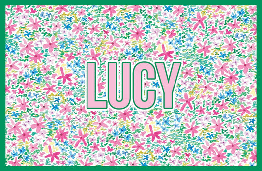 Paper placemat featuring a multicolored floral pattern and pink personalization