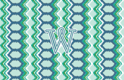 Paper placemat featuring a blue and green pattern with a teal personalized initial